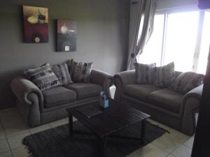 a living room with two couches and a coffee table at Kingfisher D in Shelly Beach