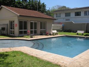 a swimming pool in front of a house at Kingfisher E in Shelly Beach