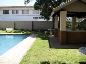 a house with a swimming pool next to a building at Kingfisher E in Shelly Beach