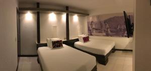 una stanza con due letti in una stanza di Hotel Maya Rue a Palenque