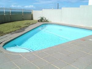 uma pequena piscina azul num quintal em La Mer A em Margate