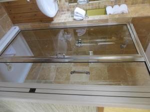 y baño con ducha de cristal y lavabo. en Buffaloberry Bed & Breakfast en Banff