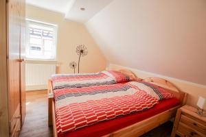 1 dormitorio con 1 cama con manta roja y ventana en Ferienwohnung Im Schlossgarten Herbsleben, en Herbsleben
