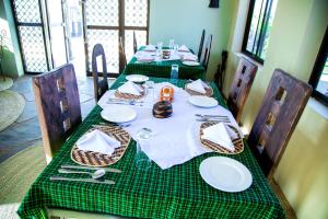 a table with a green checkered table cloth and plates at Asmorein Hotel in Babati