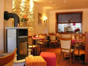 a restaurant with a fireplace and tables and chairs at Hotel & Restaurant Zum Deutschen Hause in Kirchhatten