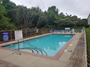 una piscina en un complejo con sillas azules en InTown Suites Extended Stay Columbus GA, en Columbus