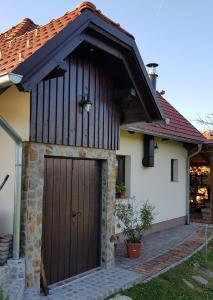 een wit huis met een houten garagedeur bij Apartma Lipek in Pristava