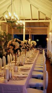 a long long table with white chairs and flowers at The Liguanea Club in Kingston