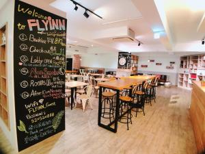 a dining room with tables and chairs and a chalkboard at Flyinn Hostel in Kaohsiung