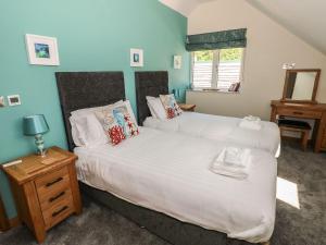 a bedroom with two beds and a table and a window at Harmon Vale in Solva