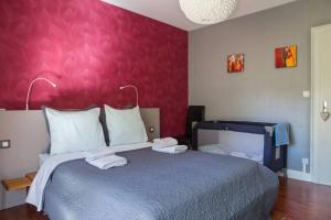 コルマールにあるAppartement La Bagatelleの赤い壁のベッドルーム1室(大型ベッド1台付)