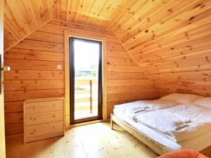 ポラニツァ・ズドルイにあるDomki Michałkiの窓付きの木造の部屋のベッド1台