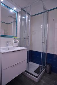uma casa de banho com uma cabina de duche em vidro e um lavatório. em Livia B&B - Trastevere em Roma