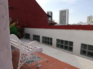 a white bench sitting on the side of a building at Hotel San Roque Cartagena in Cartagena de Indias