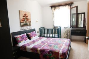 ブアブロウにあるMalama Homeのベッドルーム1室(カラフルな掛け布団付きのベッド1台付)