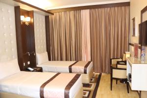Postel nebo postele na pokoji v ubytování Al Khaleej Grand Hotel