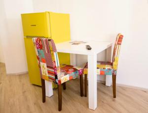 a table and two chairs next to a yellow refrigerator at Apartment Optim in Ljubljana