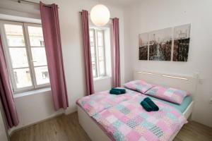 a bedroom with a bed and two windows at Apartment Optim in Ljubljana