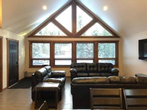 sala de estar con muebles de cuero y ventana grande en Wolf Den, en Valemount