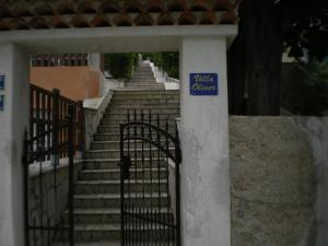 um conjunto de escadas com um portão com um sinal em APARTMANI SENKA - VILLA OLIVER em Martinšćica