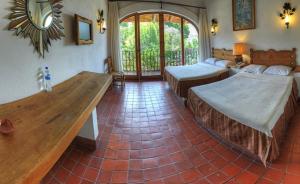 a bedroom with two beds and a large window at Posada de la Mision, Hotel Museo y Jardin in Taxco de Alarcón