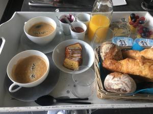 a tray with cups of coffee and pastries and bread at Ker Mouettes in Arradon