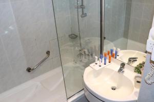 a bathroom with a shower and a toilet and a sink at Al Khaleej Grand Hotel in Dubai