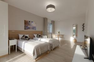 biała sypialnia z 2 łóżkami i stołem w obiekcie Apple Green Apartments w Poznaniu