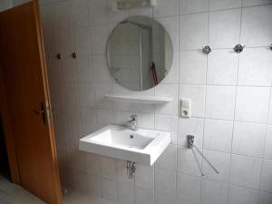 a white bathroom with a sink and a mirror at Landsitz Riekenshof in Horumersiel in Wangerland +15 photos