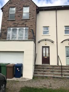 a house with a garage and a balcony at Lakelands in Seagoe