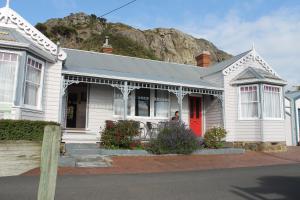 a white house with a red door and a mountain at Gardenia House in Stanley