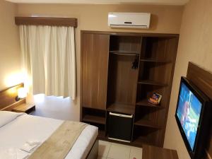 a hotel room with a bed and a television at Astro Hotel in São José dos Campos