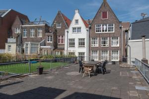 un patio con mesa y sillas frente a los edificios en Spacious Central City Apartment with big private Sundeck!, en Ámsterdam