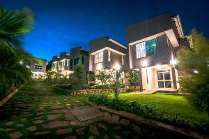 a row of houses at night with a pathway at The Pearl Cottages in Kampala