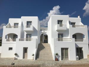 a white building with stairs in front of it at Theasis Luxury Suites in Skhoinoussa