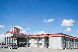 un grand bâtiment avec des voitures garées dans un parking dans l'établissement Super 8 by Wyndham Elk City, à Elk City