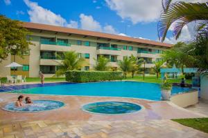 a swimming pool in front of a hotel at Carneiros Beach Particular Flat in Praia dos Carneiros