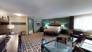 Una habitación de hotel con una cama y una sala de estar. en Bear Claw Casino & Hotel, en Kenosee Park