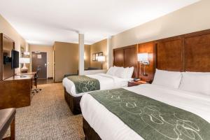 a hotel room with two beds and a desk at Comfort Suites Denver near Anschutz Medical Campus in Aurora