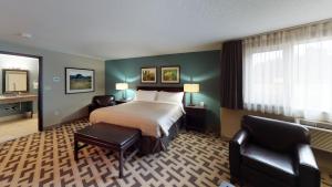 Una habitación de hotel con una cama y dos sillas. en Bear Claw Casino & Hotel, en Kenosee Park 29 fotos más