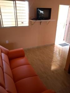 uma sala de estar com um sofá e uma televisão de ecrã plano em Casa de Veraneio Ilha de Itamaracá em Itamaracá