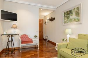 sala de estar con sofá y silla en Charming Argüelles, en Madrid