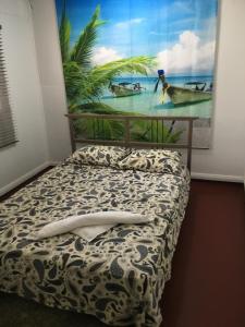 un letto in una stanza con un dipinto sul muro di Ocean View Apartments a Flying Fish Cove