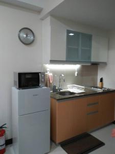 a kitchen with a sink and a microwave at 101 Newport Blvd Condotel in Manila