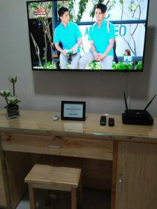 a television with two men on it sitting on a desk at 101 Newport Blvd Condotel in Manila