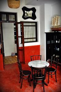 a dining room with a table and four chairs at 99 Oldtown Boutique Guesthouse SHA EXTRA PLUS in Phuket