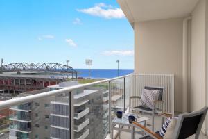 a balcony with chairs and a view of the ocean at Sage Hotel Wollongong in Wollongong