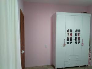 a white cabinet in a room with shoes on it at Casa de férias in Governador Celso Ramos