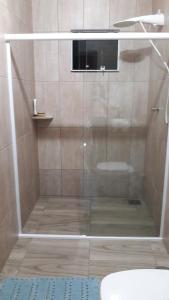 a shower with a glass door in a bathroom at Casa de férias in Governador Celso Ramos +10 photos