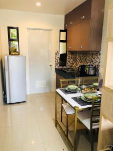 a kitchen with a table and a refrigerator at Contemporary cozy 6- 2BR Apartment in Davao City